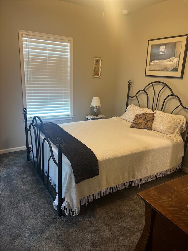 bedroom featuring dark colored carpet and baseboards