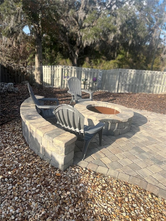 view of patio / terrace with an outdoor fire pit and fence