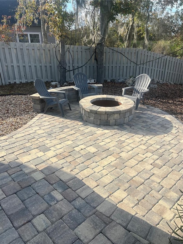 view of patio with an outdoor fire pit and fence