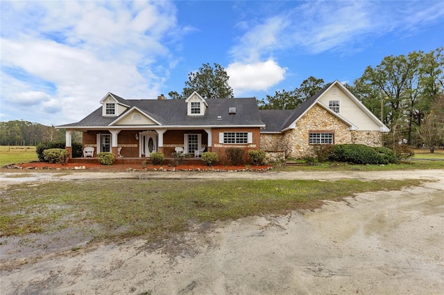 view of front of home featuring covered porch and a front lawn