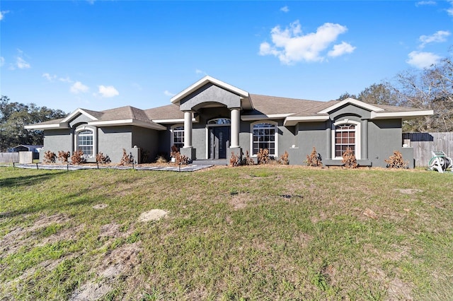 ranch-style house with stucco siding, fence, and a front yard