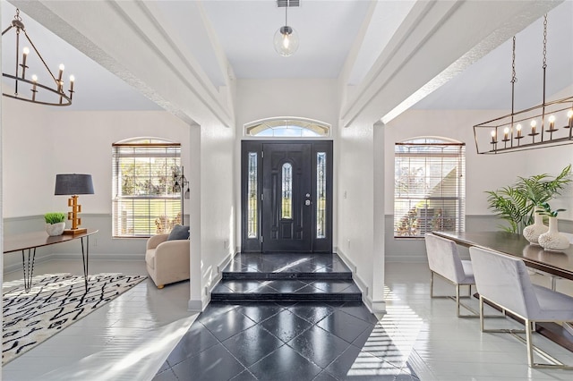 foyer featuring a notable chandelier and baseboards