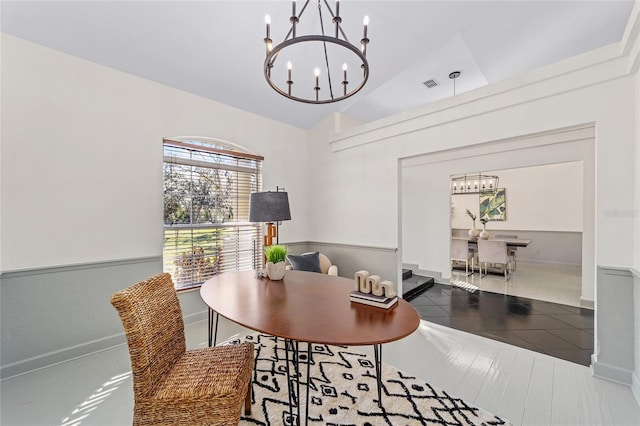 dining area with vaulted ceiling, visible vents, and an inviting chandelier