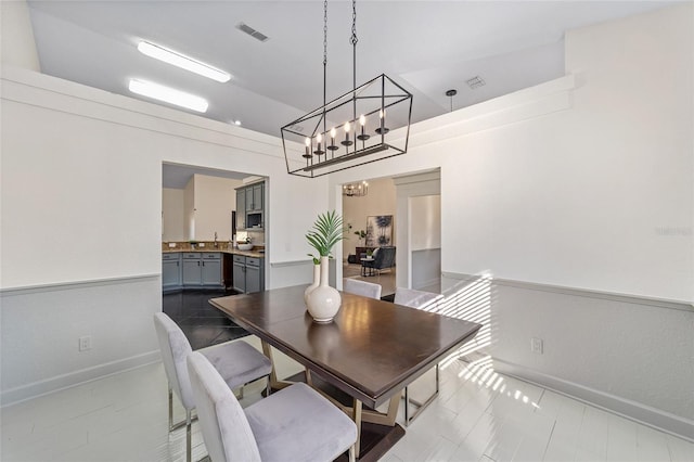 dining room featuring an inviting chandelier, baseboards, and visible vents