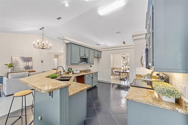 kitchen featuring appliances with stainless steel finishes, backsplash, a sink, and a peninsula