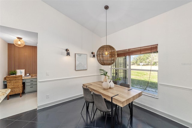 dining space with vaulted ceiling and baseboards