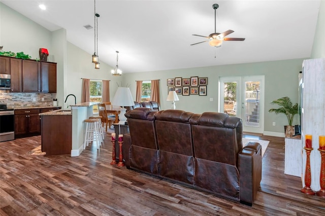 living room featuring dark wood-type flooring, visible vents, high vaulted ceiling, and a ceiling fan