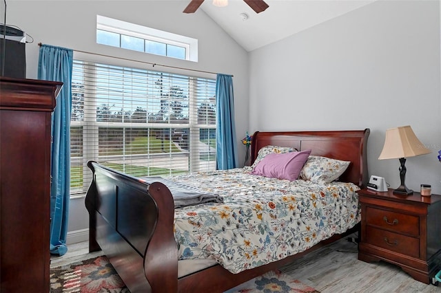 bedroom with a ceiling fan, lofted ceiling, and light wood finished floors