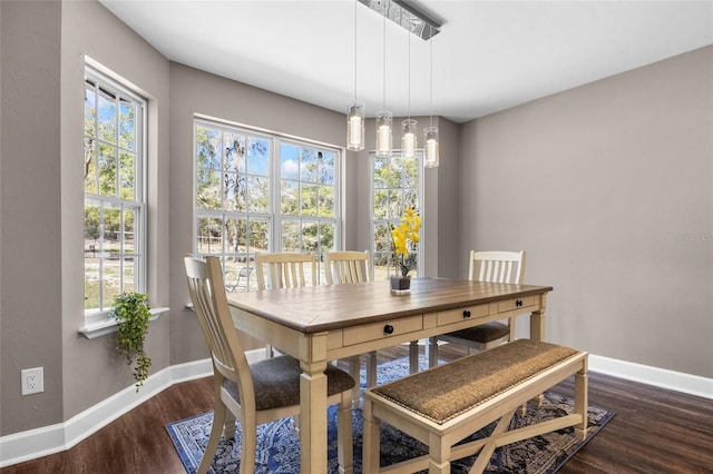 dining area with baseboards and wood finished floors