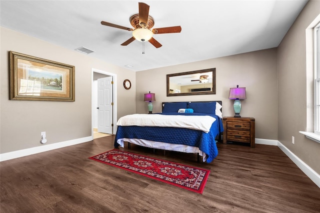 bedroom with a ceiling fan, visible vents, wood finished floors, and baseboards