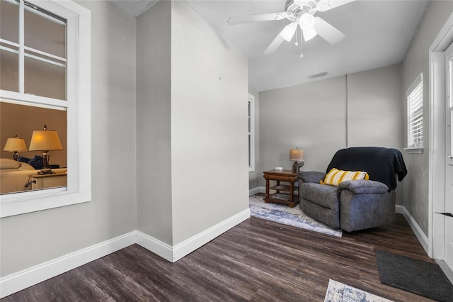 sitting room with a ceiling fan, wood finished floors, visible vents, and baseboards