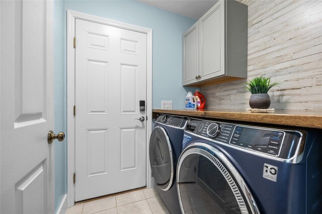 washroom with cabinet space, separate washer and dryer, and light tile patterned flooring