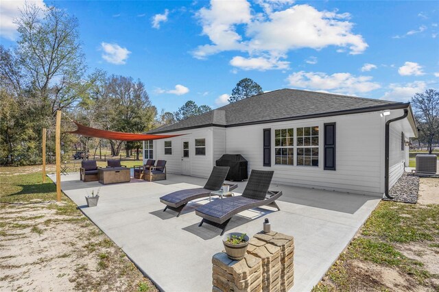 back of house featuring outdoor lounge area, a patio, cooling unit, and roof with shingles