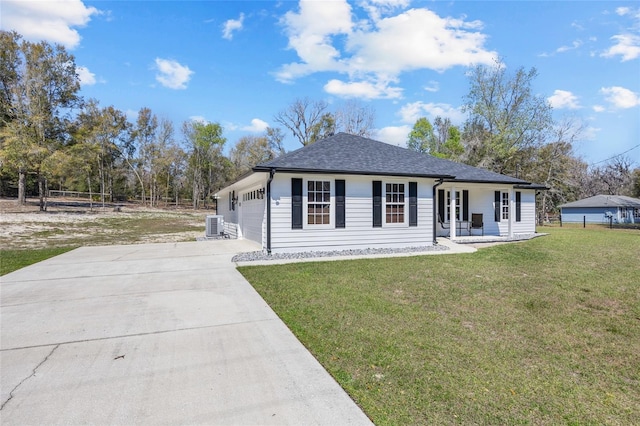 view of front of home with central AC unit, driveway, a shingled roof, a front lawn, and a garage