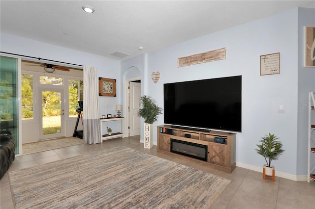 tiled living room featuring ceiling fan