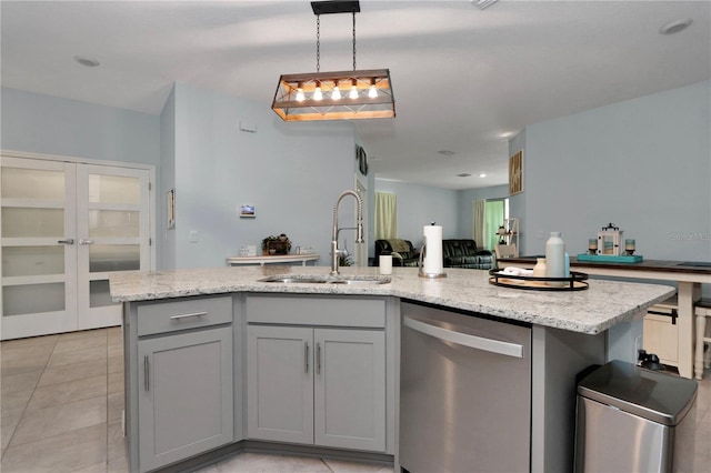 kitchen featuring decorative light fixtures, dishwasher, sink, gray cabinetry, and a center island with sink