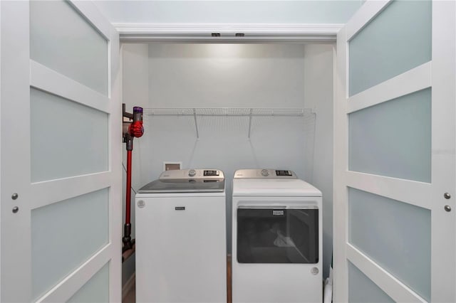 clothes washing area with washing machine and dryer