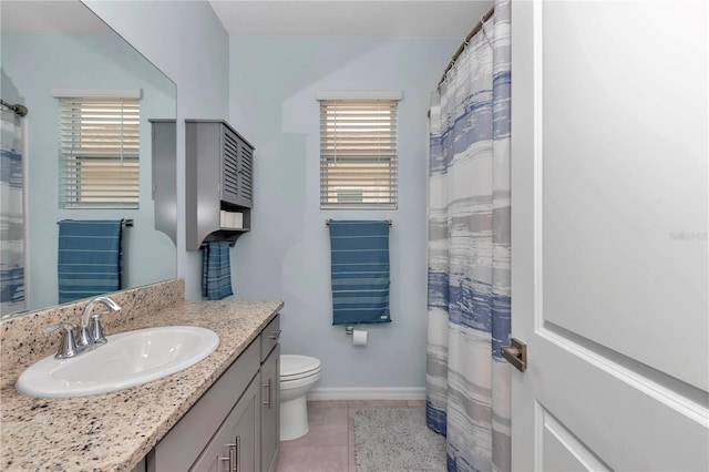 bathroom featuring vanity, a wealth of natural light, tile patterned floors, and toilet