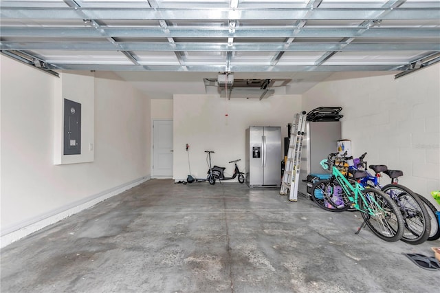 garage featuring a garage door opener, stainless steel fridge, and electric panel