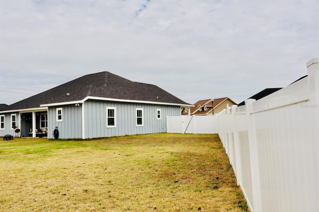 rear view of property with a yard