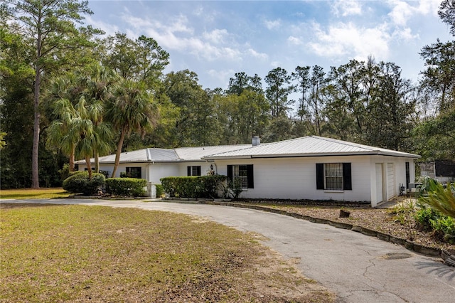 single story home featuring a garage and a front yard