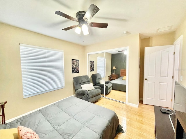 bedroom with ceiling fan, light hardwood / wood-style floors, and a closet