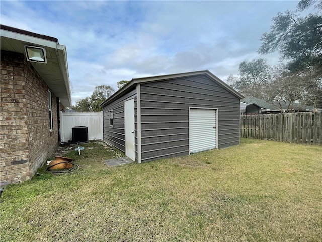 view of outbuilding featuring a yard and central AC