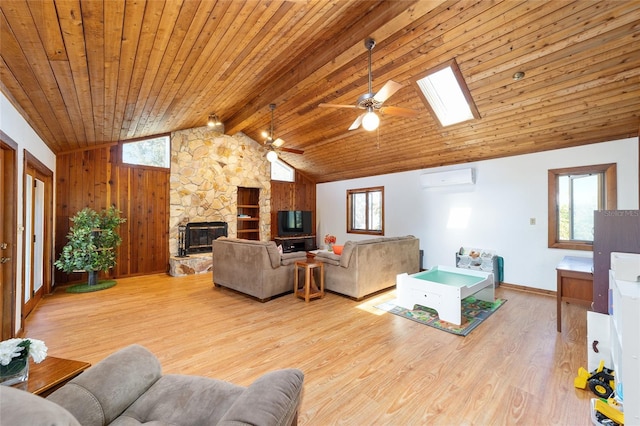 living area with a stone fireplace, wooden ceiling, a skylight, a wall mounted AC, and light wood finished floors