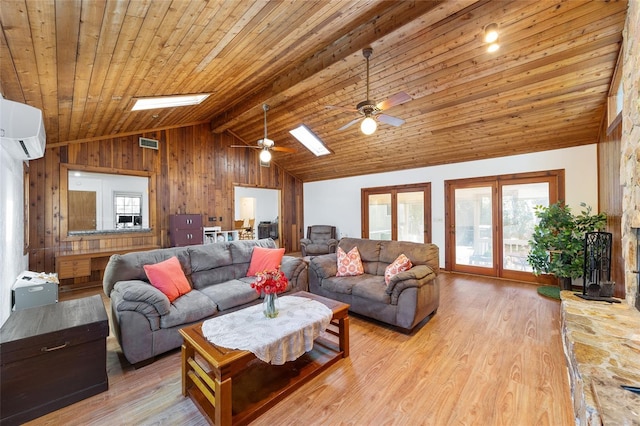 living room with wood finished floors, a skylight, a wall unit AC, and a wealth of natural light