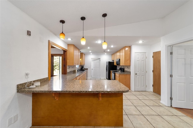 kitchen featuring a breakfast bar area, recessed lighting, light tile patterned flooring, a peninsula, and black appliances