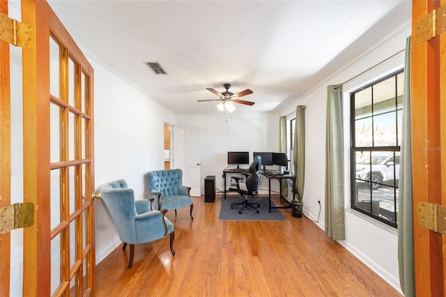 office with ceiling fan, light wood-style flooring, visible vents, baseboards, and ornamental molding