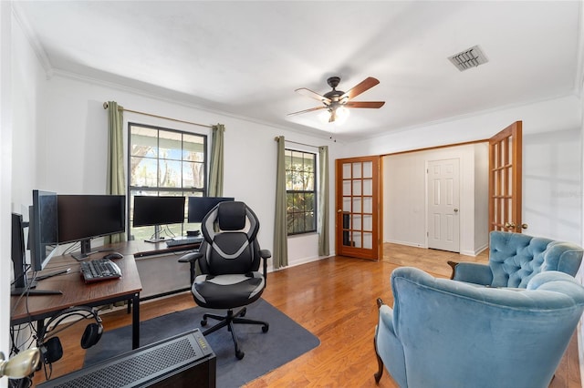 office with ceiling fan, visible vents, light wood-style floors, french doors, and ornamental molding