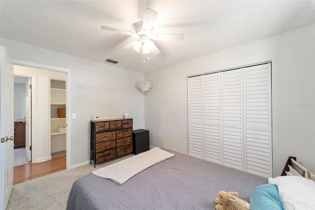 bedroom with baseboards, visible vents, ceiling fan, carpet flooring, and a closet