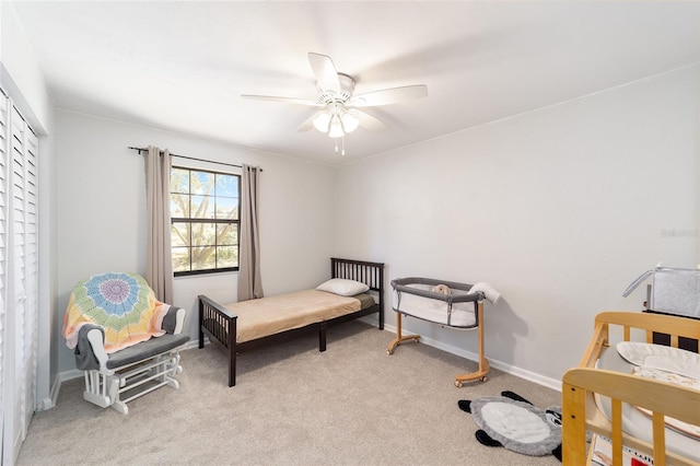 bedroom featuring a ceiling fan, light colored carpet, and baseboards