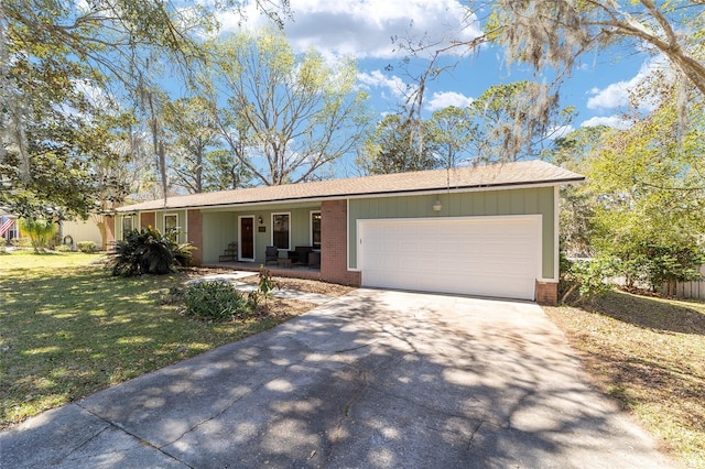 ranch-style house with brick siding, covered porch, an attached garage, driveway, and a front lawn