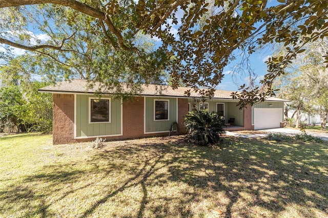 single story home featuring a garage, a front yard, concrete driveway, and brick siding