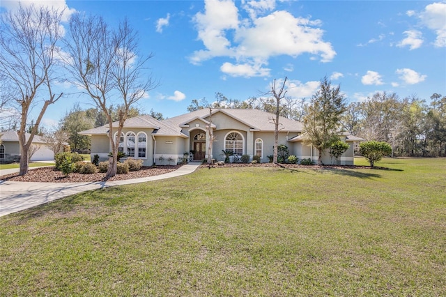 view of front of house with driveway, stucco siding, and a front yard