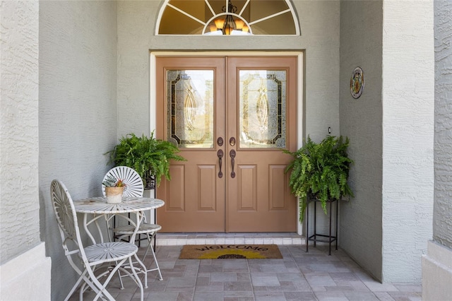 property entrance featuring french doors and stucco siding