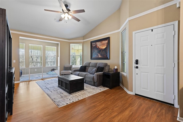 living area featuring vaulted ceiling, wood finished floors, a ceiling fan, and baseboards