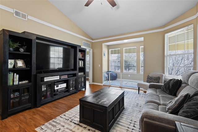 living room with baseboards, visible vents, vaulted ceiling, and wood finished floors