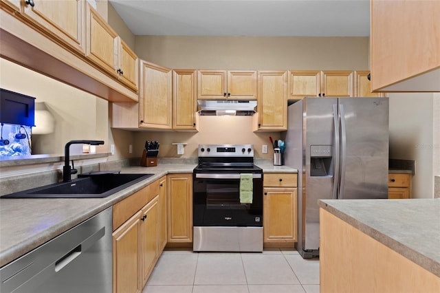 kitchen with light tile patterned floors, under cabinet range hood, a sink, appliances with stainless steel finishes, and light brown cabinetry