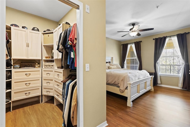 bedroom with dark wood-style floors, baseboards, and a ceiling fan