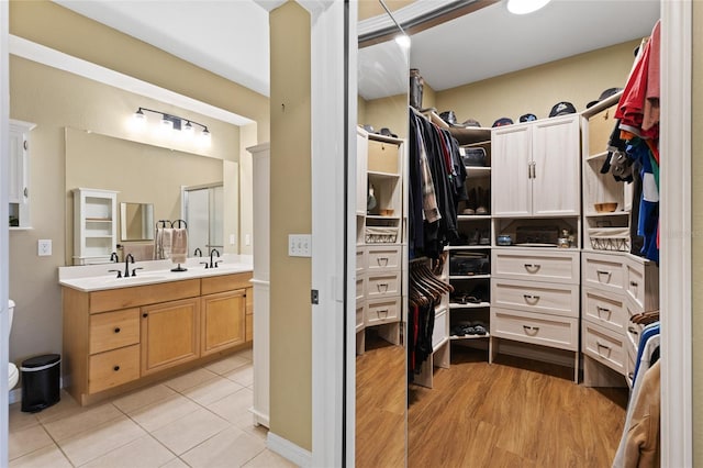 spacious closet featuring light tile patterned flooring and a sink