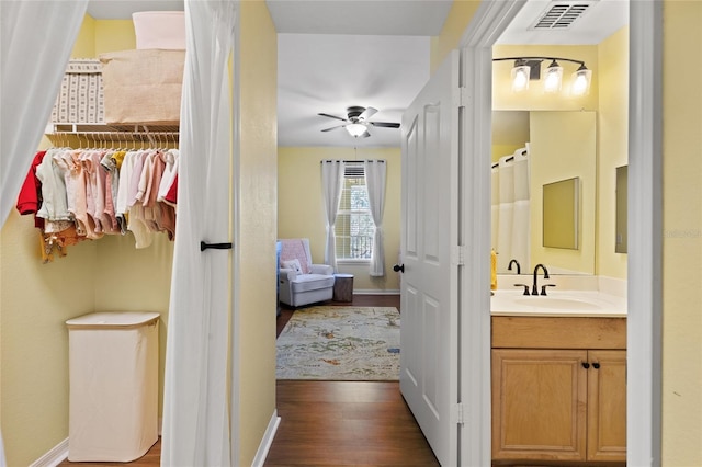 bathroom with vanity, wood finished floors, visible vents, and baseboards