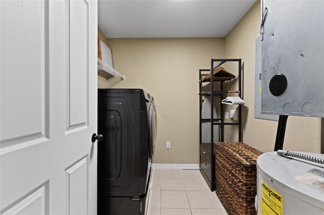 laundry area featuring light tile patterned flooring, laundry area, baseboards, water heater, and washer / dryer