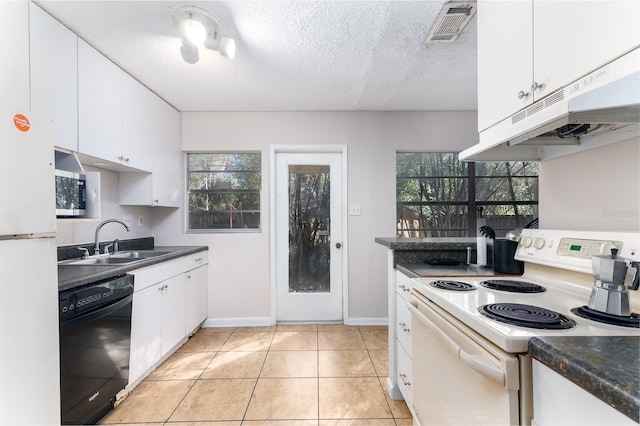 kitchen with white appliances, visible vents, under cabinet range hood, white cabinetry, and a sink