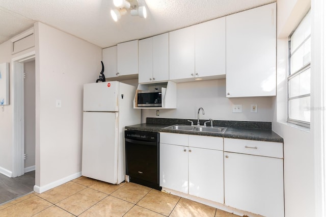 kitchen featuring a sink, white cabinetry, freestanding refrigerator, dishwasher, and stainless steel microwave