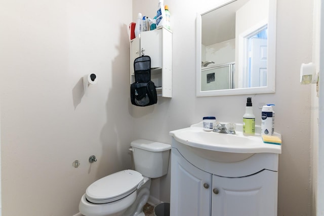 bathroom featuring toilet, vanity, and baseboards