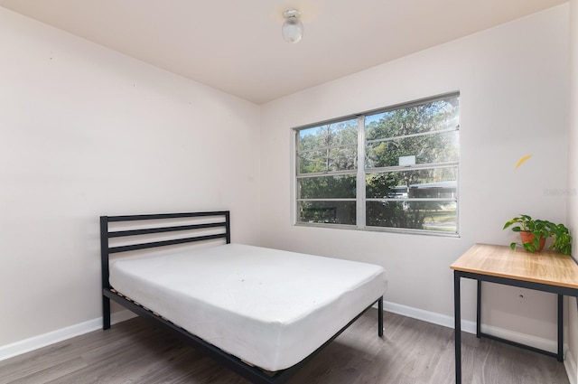 bedroom featuring dark wood-style flooring and baseboards