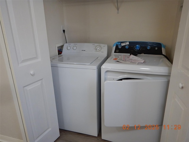 laundry area with laundry area, separate washer and dryer, and wood finished floors